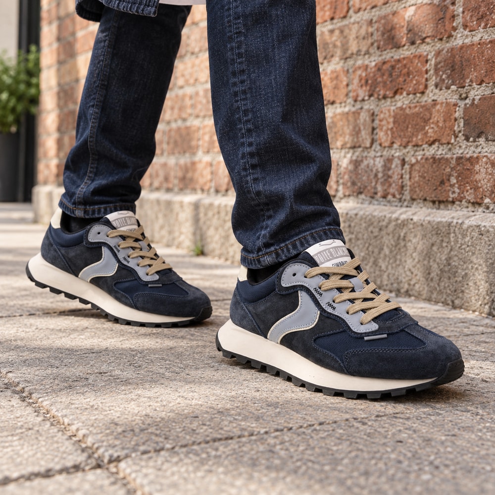 Ambientación con IA: Zapatillas Voile Blanche Qwark Flash de hombre en azul, puesto con pantalones.
