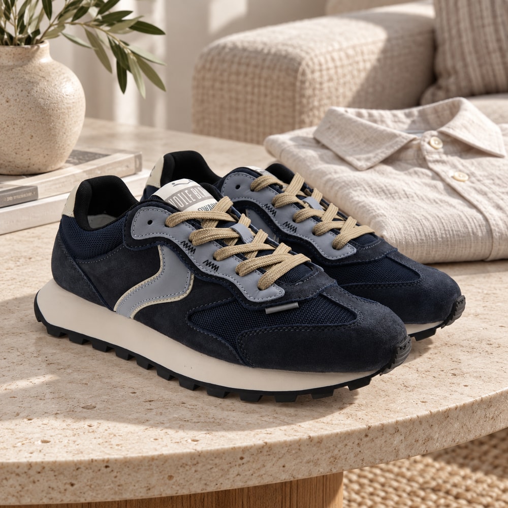 Ambientación con IA: Zapatillas Voile Blanche Qwark Flash de hombre en azul, junto a prendas lisas.