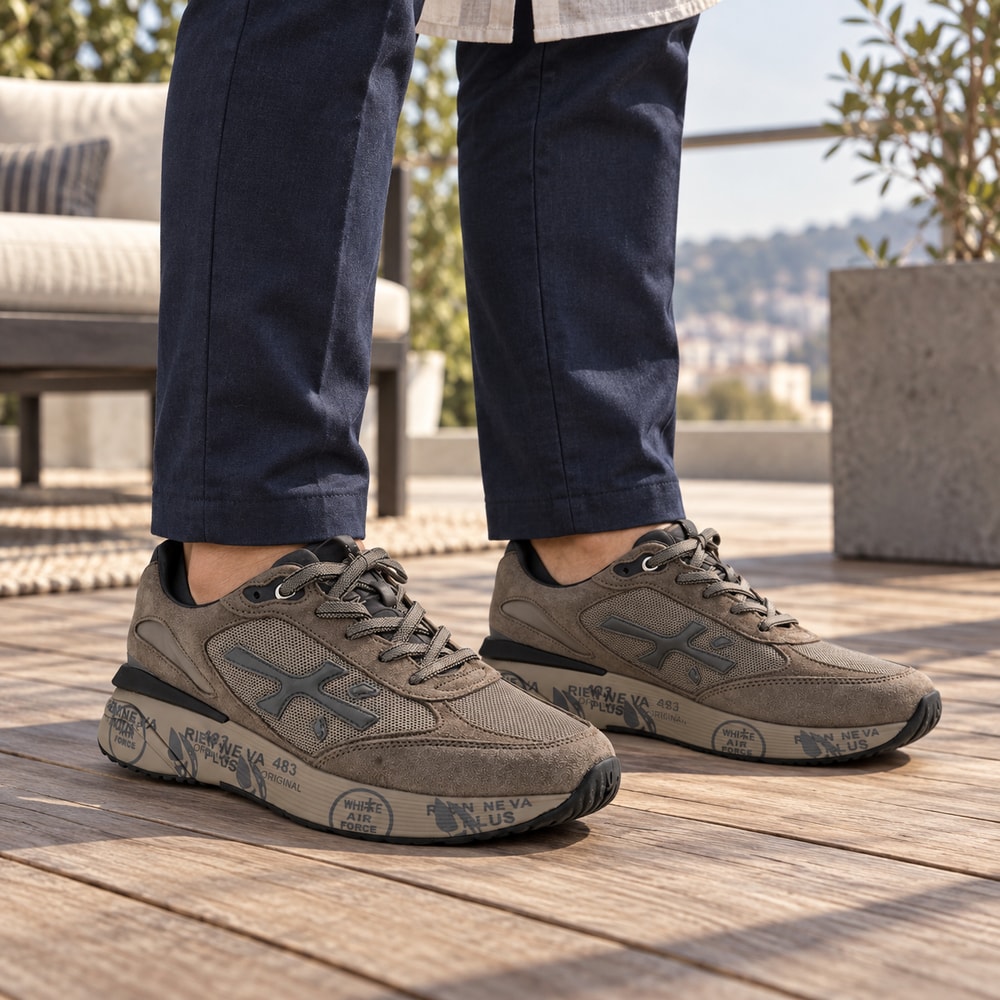 Ambientación con IA: Zapatillas Premiata Moerun de hombre en marrón, puesto con pantalones.