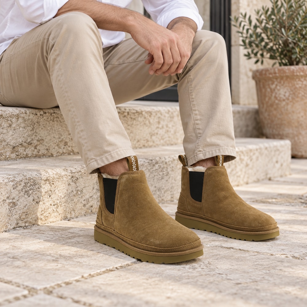 Ambientación con IA: Botas UGG Neumel Chelsea de hombre en color cuero, puesto con pantalones.
