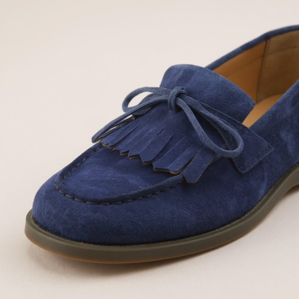 Detalle de los materiales y costuras de un mocasín azul CALCE, mostrando la calidad del nubuck y la piel.