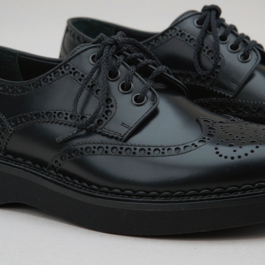 Primer plano de los zapatos CALCE blucher negros, mostrando la calidad de la piel, las costuras y el acabado artesanal.