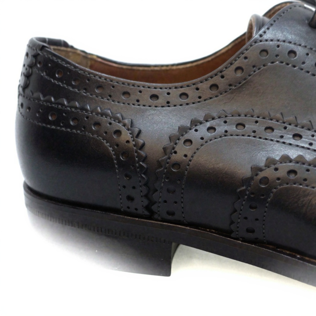 Primer plano detallado del zapato ZAMPIERE blucher negro, mostrando la piel VITELLO, la construcción Blake y la suela de cuero.