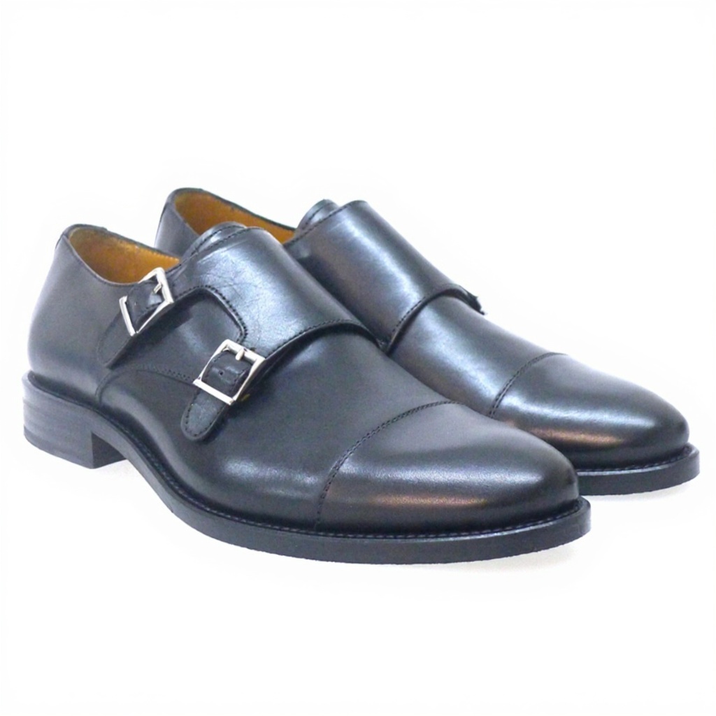 Un caballero con traje de sastre azul oscuro, calzando los elegantes zapatos PERTINI 2 hebillas negros, paseando por un distrito financiero.