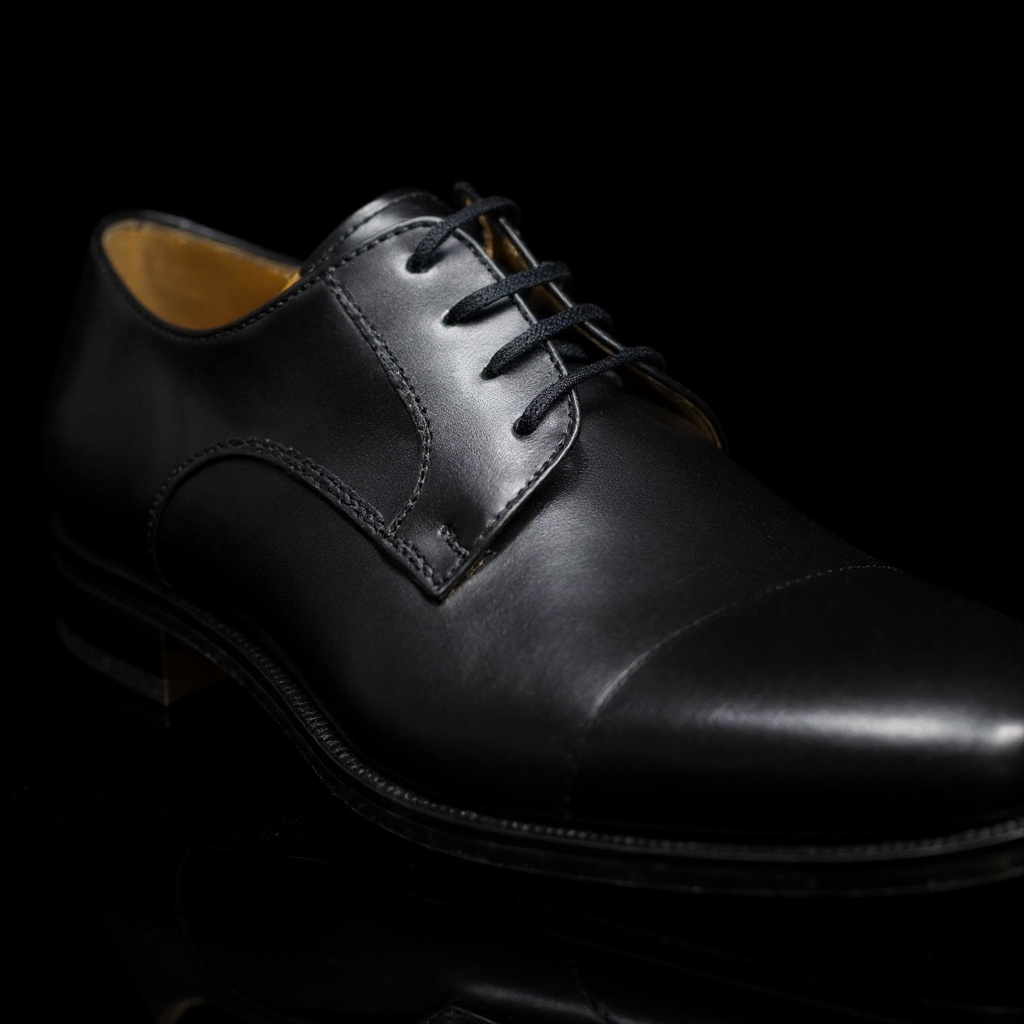 Detalle en primer plano de los zapatos PERTINI ceremonia negros, mostrando la textura de la piel y la suela.