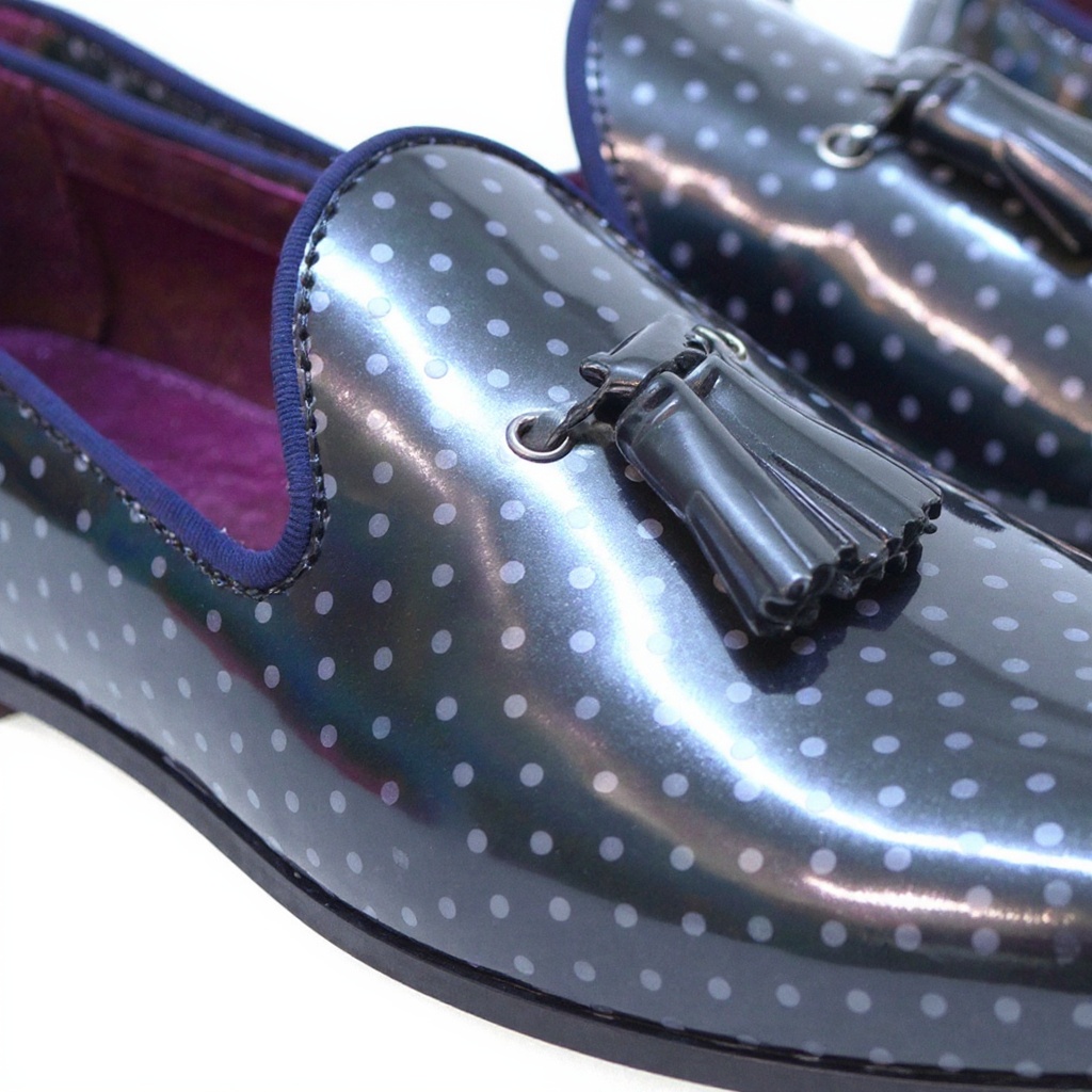 Detalle técnico del slipper TED BAKER negro, mostrando el charol brillante, la costura y la suela, resaltando la calidad de los materiales.