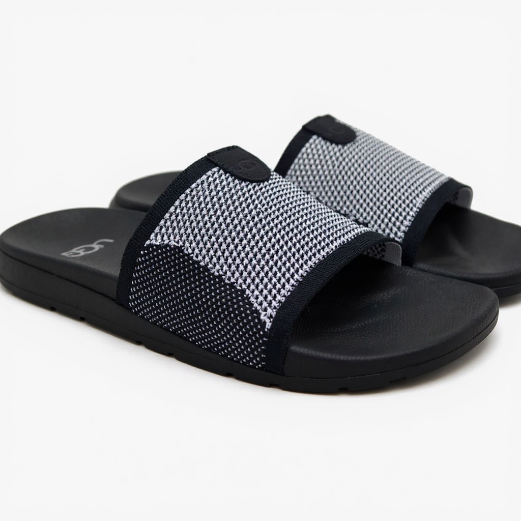 Primer plano técnico de la sandalia UGG pala negra, destacando los materiales BLOK y TECNICO, la suela ergonómica y la construcción de calidad.