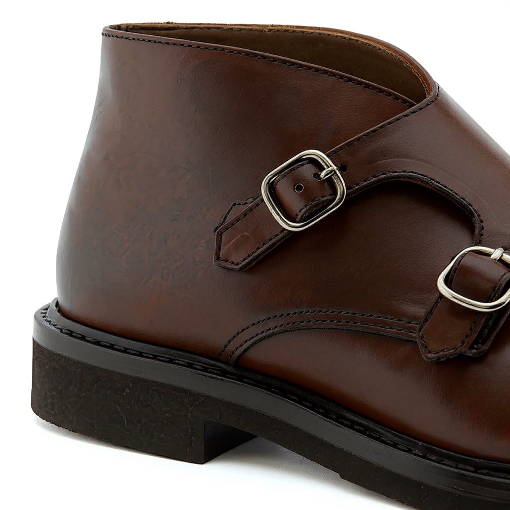 Detalle técnico de la bota CALCE de hebilla, mostrando la piel de alta calidad, el suede, las costuras y la robusta suela.